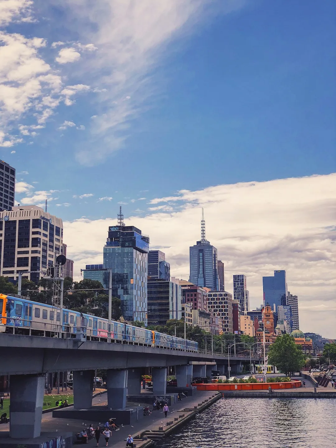 City skyline with train on elevated track and river
