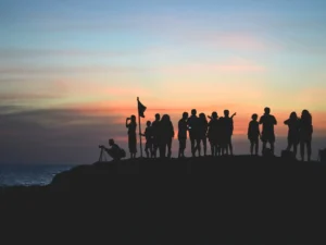 silhouette photography of people gathered together on cliff